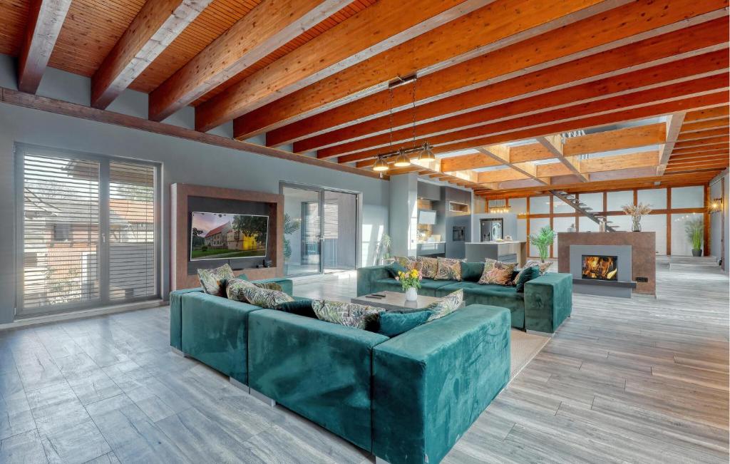 a living room with green couches and a fireplace at Luxusvilla Mit Kegelbahn in Bahrdorf