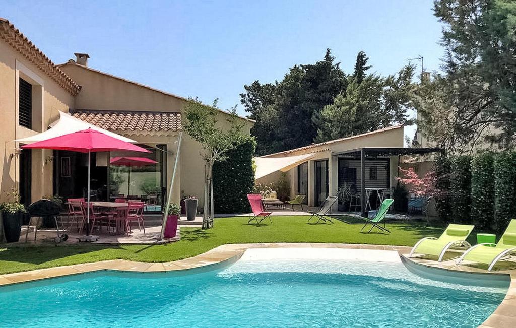 a house with a swimming pool with chairs and a table at La Villa De Sévigné in Rognonas