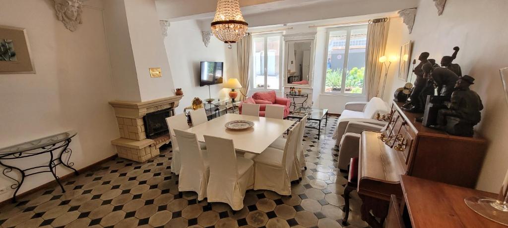 a living room with a table and a dining room at Appartements de charme La Sarrazine in La Garde-Freinet