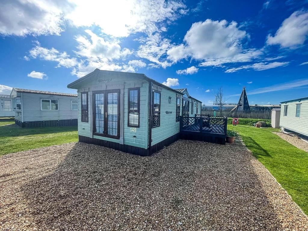 a tiny house sitting on gravel in a yard at Great 4 Berth Caravan For Hire In Suffolk At North Denes, Ref 40149nd in Lowestoft