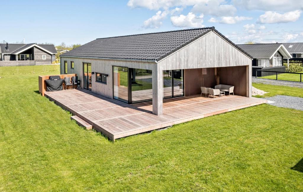 ein Haus mit einer Terrasse im Hof in der Unterkunft Cozy Home In Fllenslev With Wifi in Føllenslev