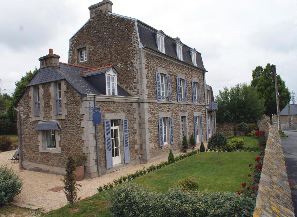 ein großes Backsteinhaus mit einem Hof davor in der Unterkunft La Gougeonnais in La Richardais