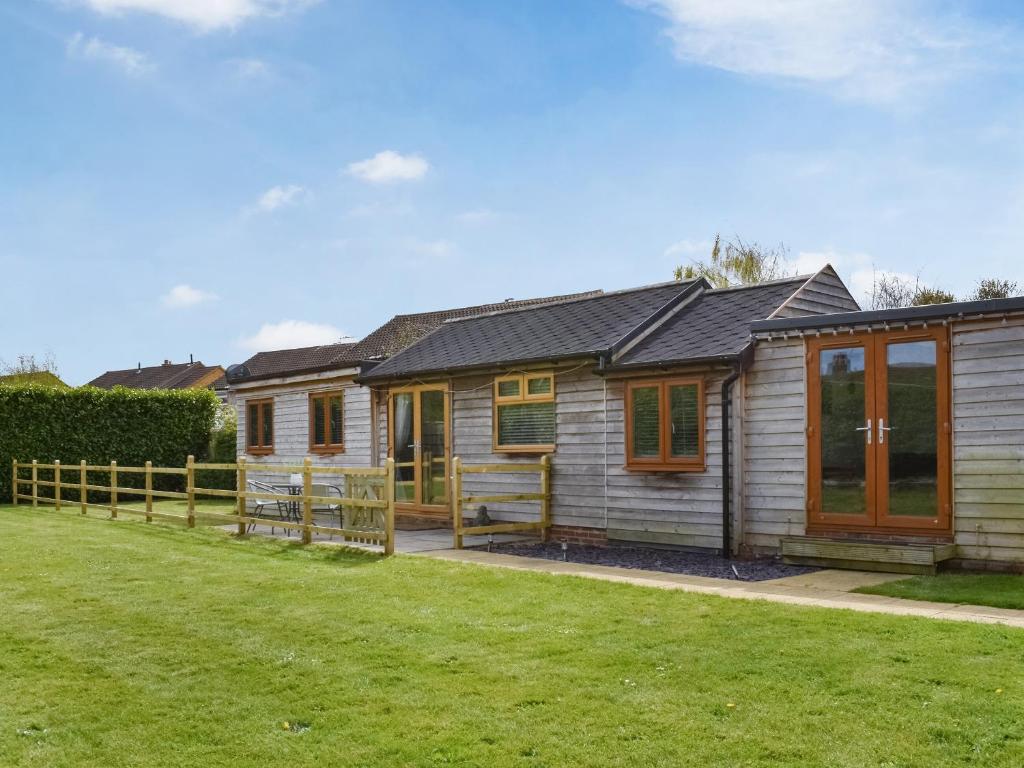 een klein houten huis met een groene tuin bij Spring Lodge in Southbourne