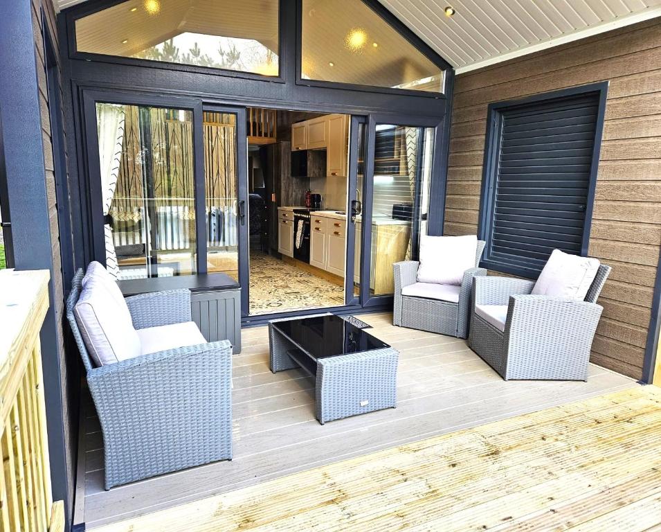 a screened in porch with two chairs and a table at Pods 1 and 2 Willow Bank in Market Rasen