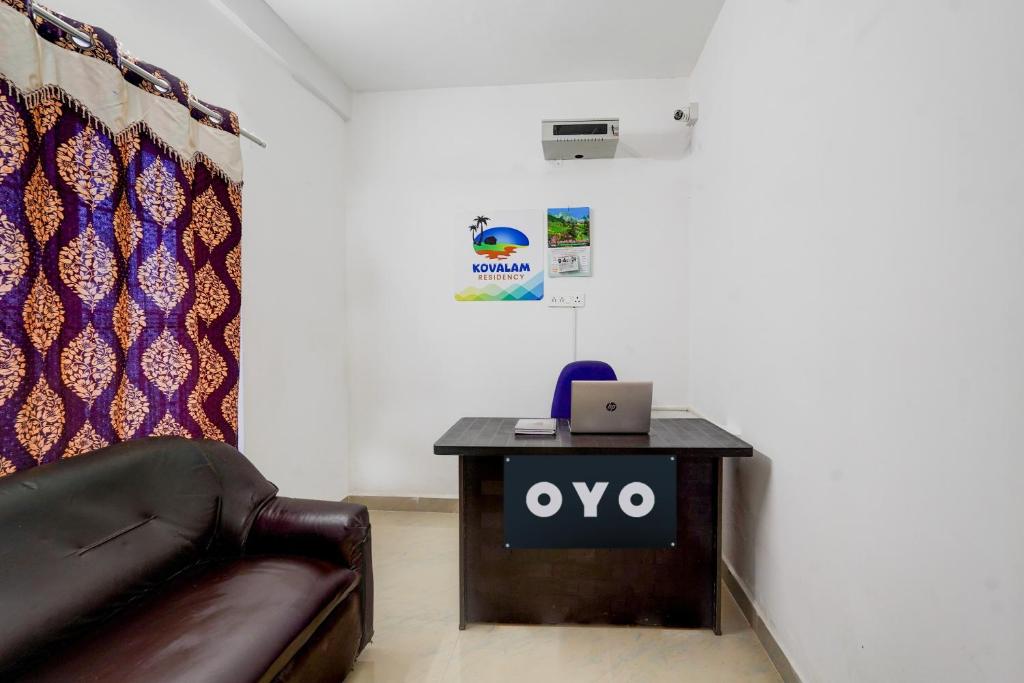 a office with a table with a laptop on it at OYO Kovalam Residency in Chennai