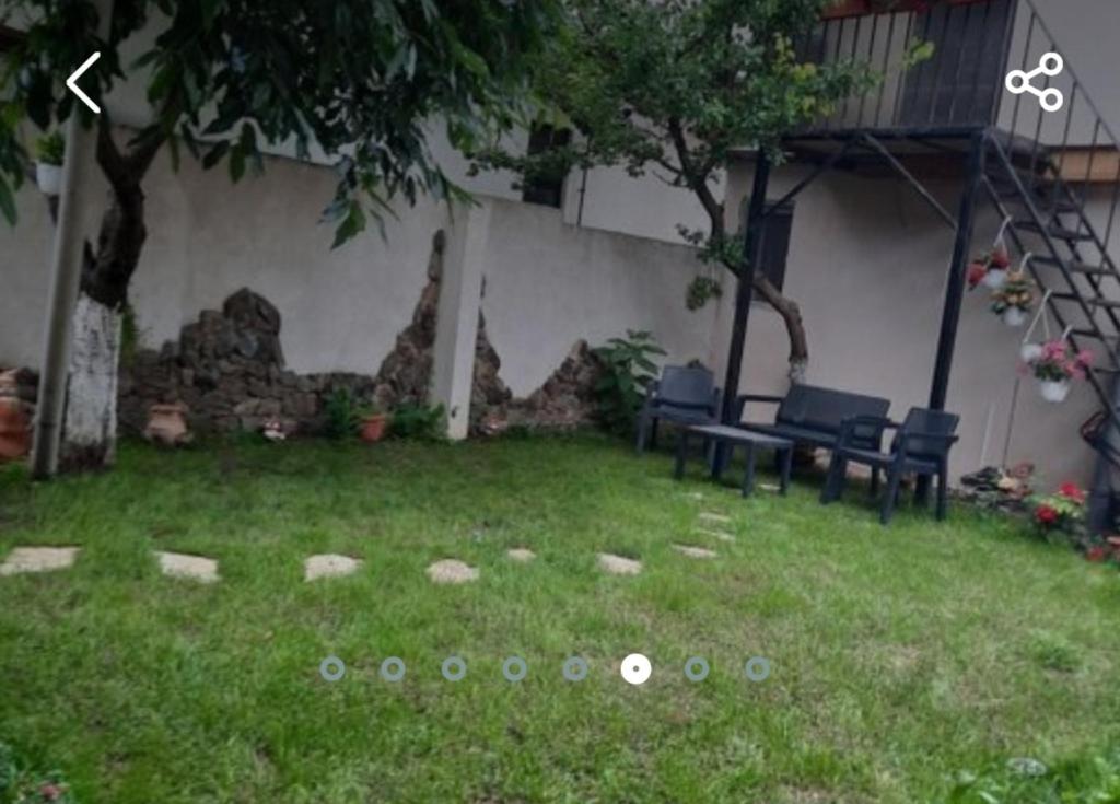 a yard with two chairs and a table in the grass at La Ani și Vasile in Năvodari