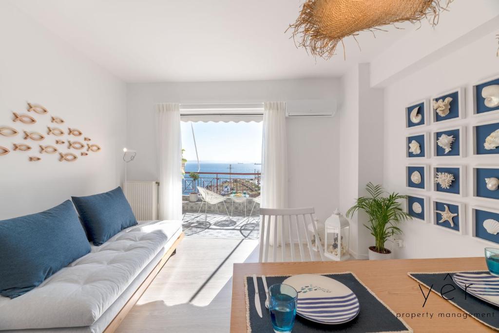 a living room with a white couch and a table at Shell-Charm w/Sea View & Parking in Piraeus
