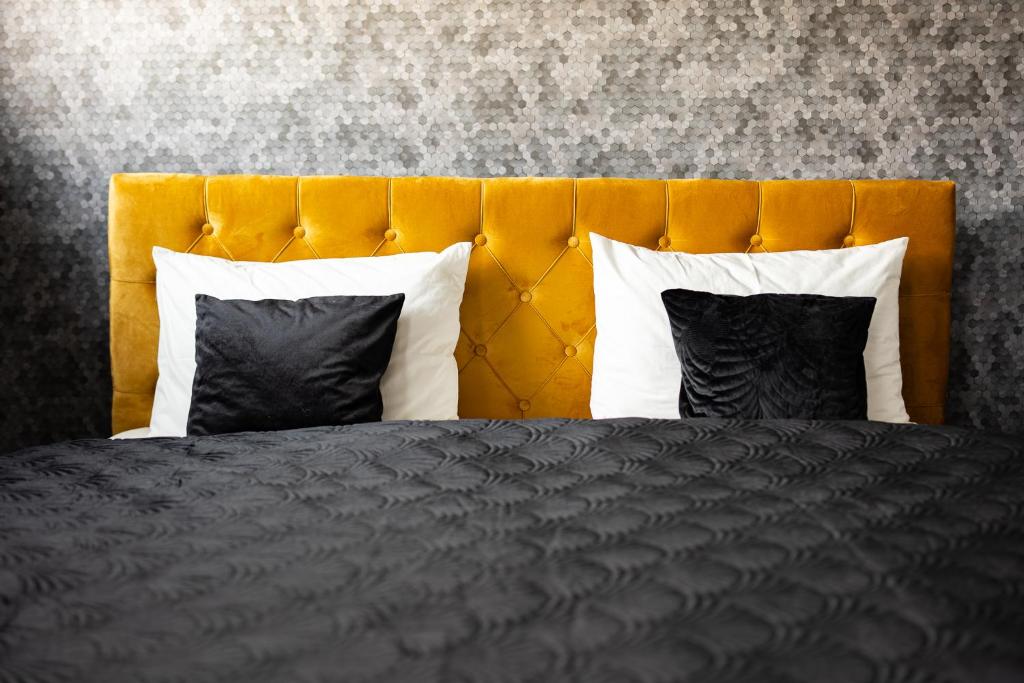 um quarto com uma cama preta e uma cabeceira amarela em Villa Sinaloa-Spa em Ruda Śląska
