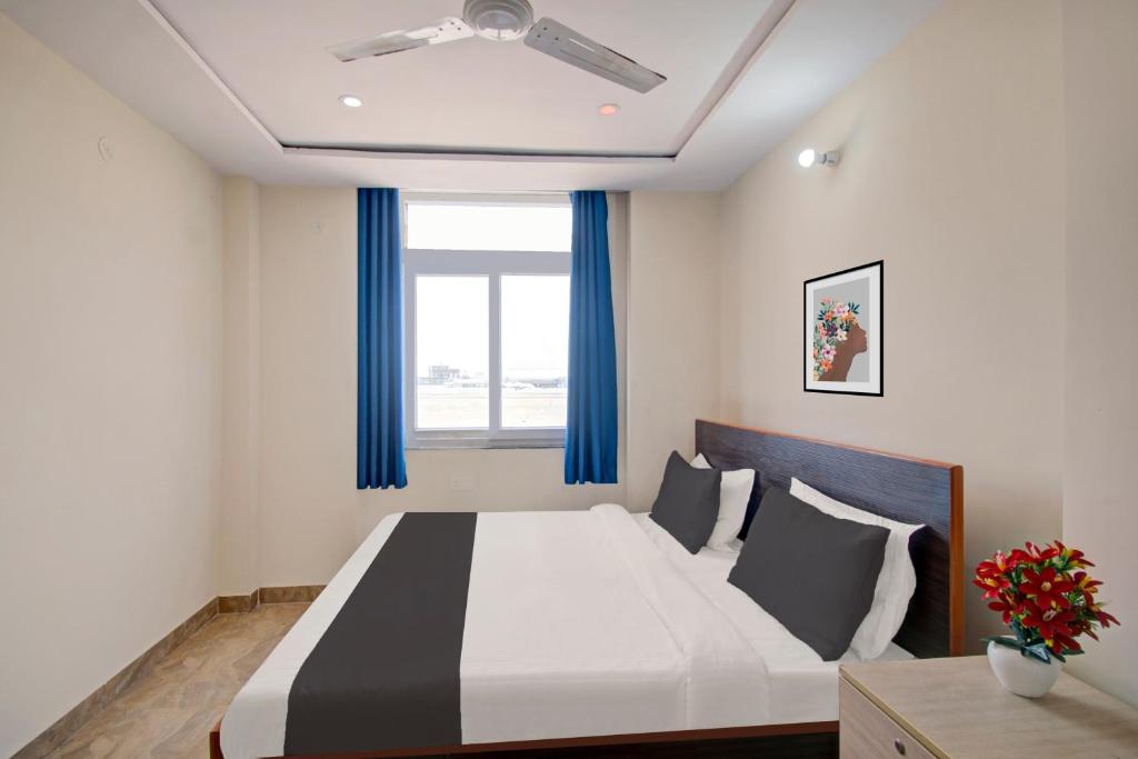um quarto com uma cama grande e cortinas azuis em OYO Samrat P Guest House em Jaipur