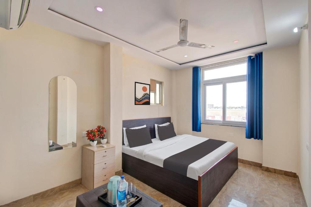 OYO Samrat P Guest House في جايبور: غرفة نوم بسرير كبير ونافذة