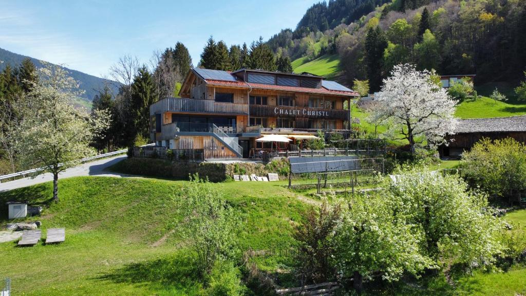 a large house on top of a hill with trees at Chalet Christl Panorama Appartements in Schruns