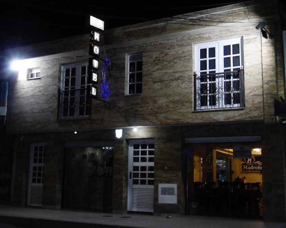 un bâtiment avec un panneau sur son côté la nuit dans l'établissement Hotel Restaurante El Madroño Chia, à Chía