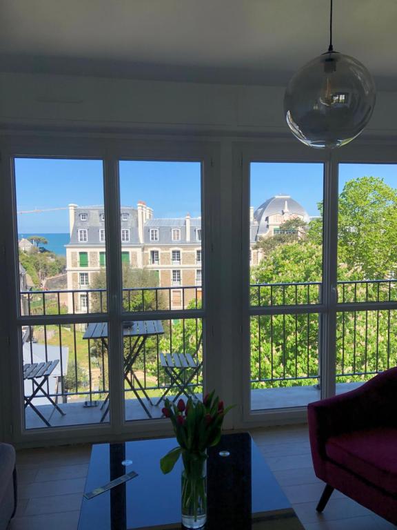 uma sala de estar com janelas com vista para um edifício em Studio tout confort apercu mer em Dinard