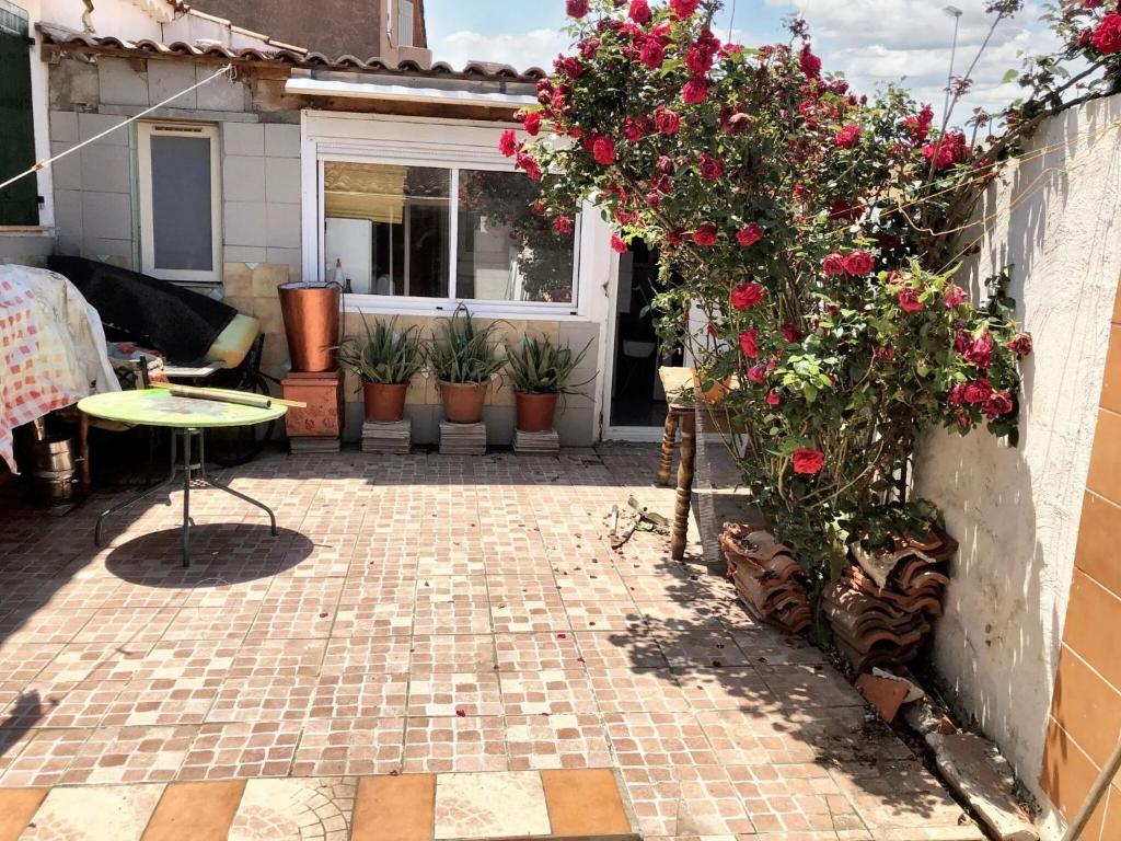 un patio con un ramo de flores y una mesa en Maison d'une chambre avec jardin clos et wifi a Avignon, en Aviñón