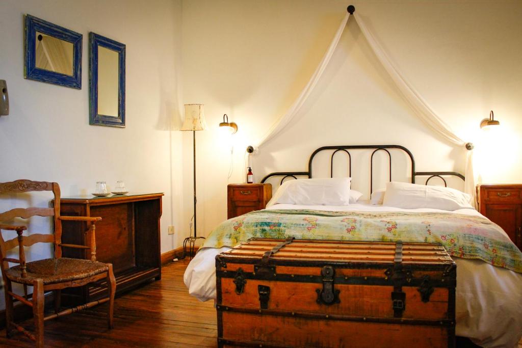 a bedroom with a bed with a trunk on it at Antigua Casona Bed & Breakfast in San Antonio de Areco