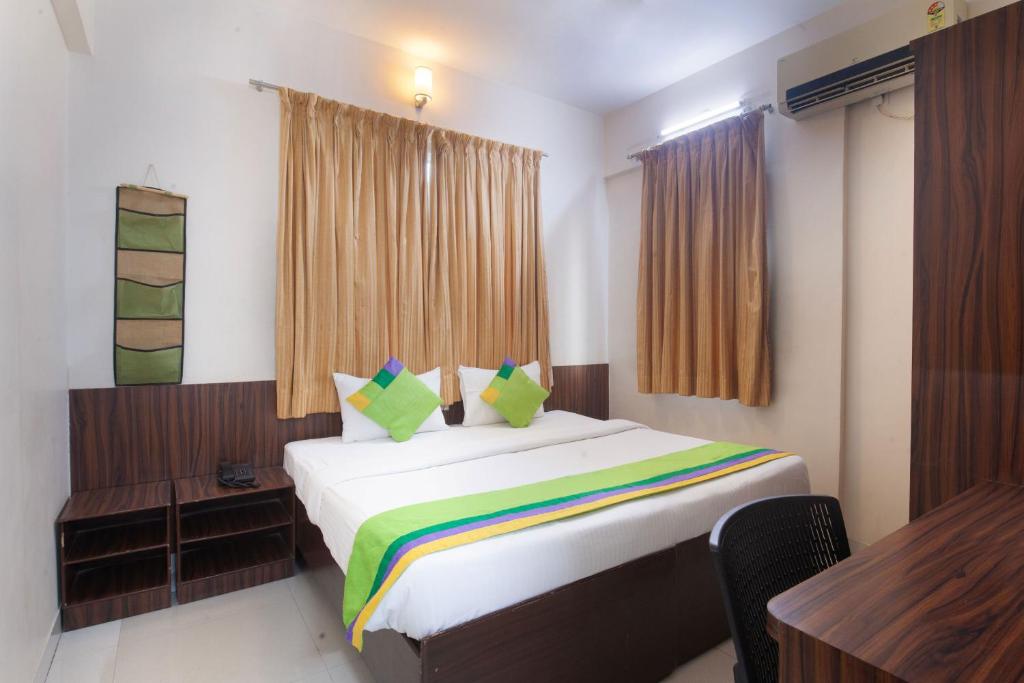 a bedroom with a bed and a table and a desk at Treebo Trend Park View Hadapsar in Pune