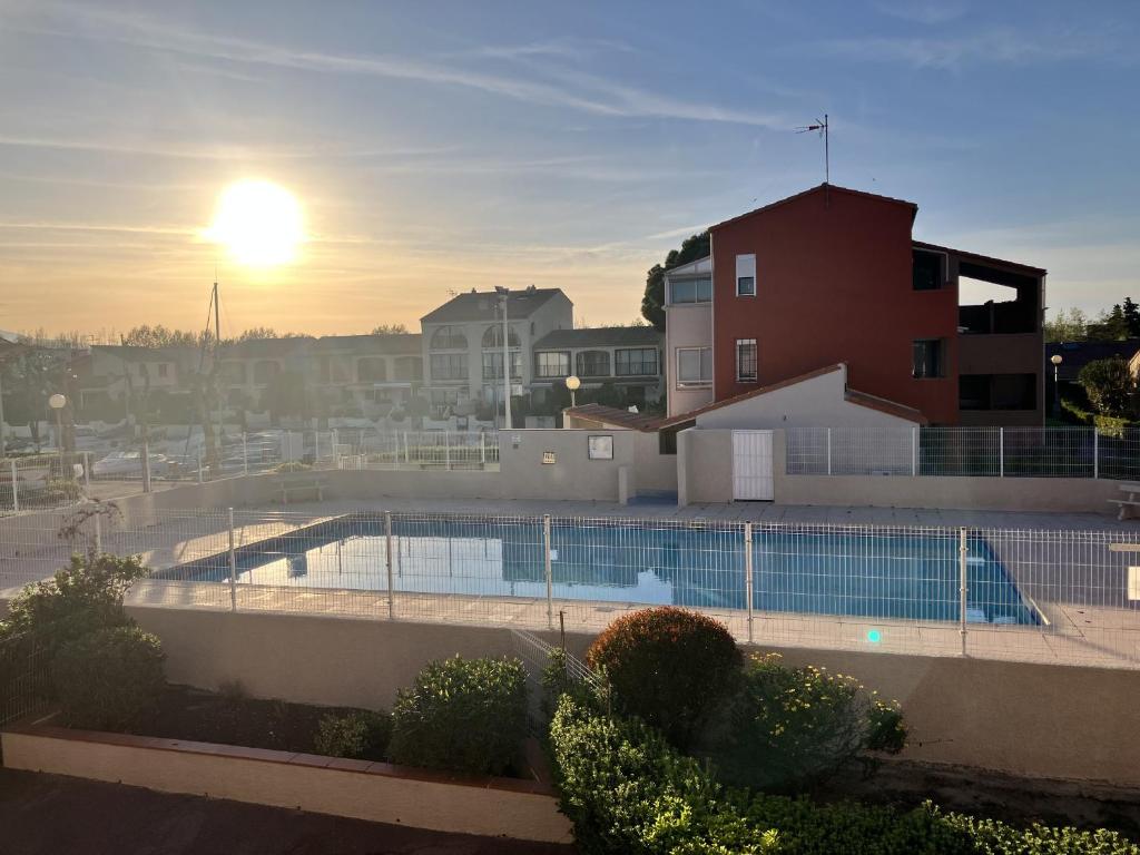 - une piscine avec vue sur le coucher du soleil en arrière-plan dans l'établissement St cyprien appartement en residence avec piscine, à Saint-Cyprien