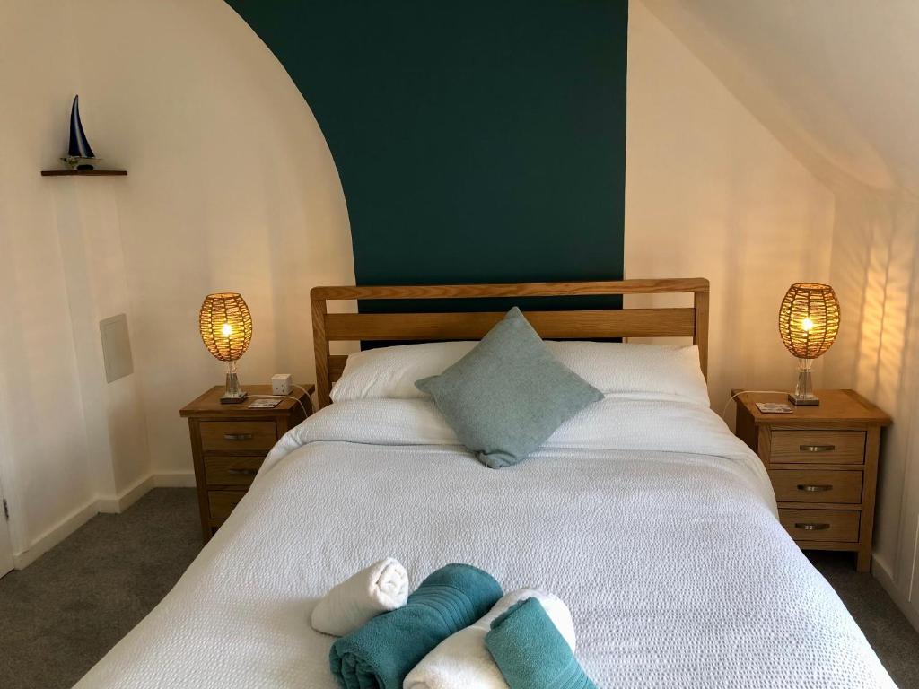 ein Schlafzimmer mit einem Bett mit zwei Handtüchern darauf in der Unterkunft Knoll Guest House in Cromer