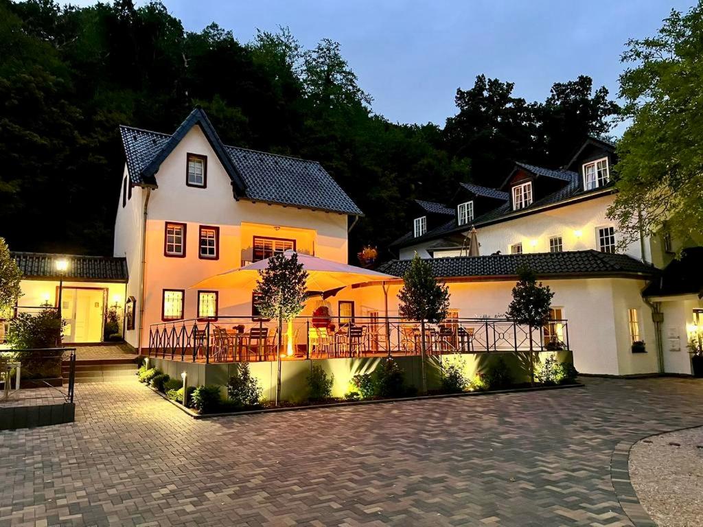 バート・ミュンスターアイフェルにあるLandgasthaus Steinsmühleの目の前にテーブルと椅子が置かれた建物