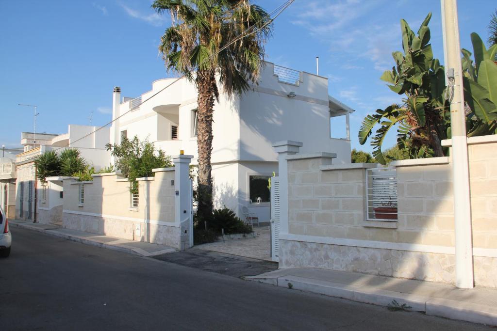 una casa blanca con una palmera en una calle en B&B Valentino, en Bari