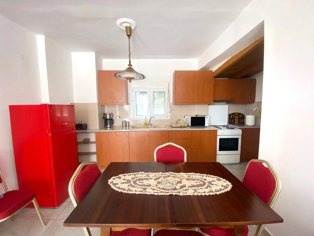 a kitchen with a wooden table and red appliances at Stone House in the foothills of Taygetos in Xirokámbion