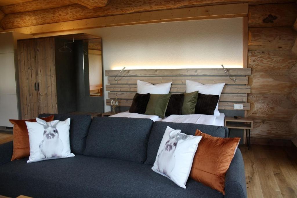 a living room with a couch and a bed at Waldzeit Lodge - Ferienwohnung Hase in NeuhÃ¼tten
