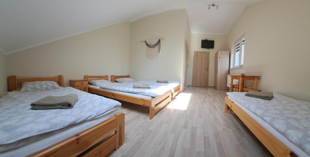 a bedroom with two beds and a tv in it at Pokoje Izabela - Noclegi Graboszyce - Zator in Graboszyce