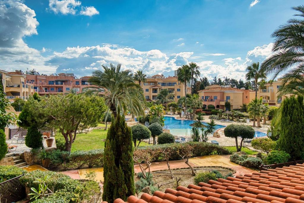 a view of a resort with a swimming pool and palm trees at Limnaria Gardens B103 in Paphos