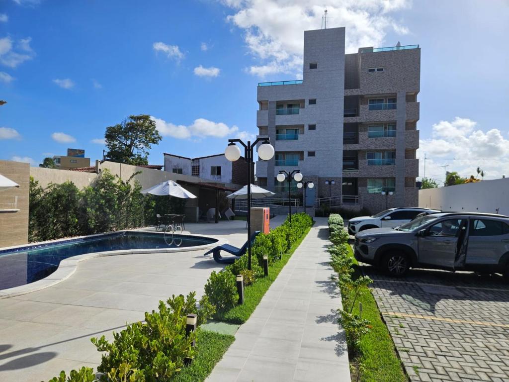 a car parked in a parking lot next to a building at Apartamento Encantador - MAKAMBIRA RESIDENCE in Porto De Galinhas