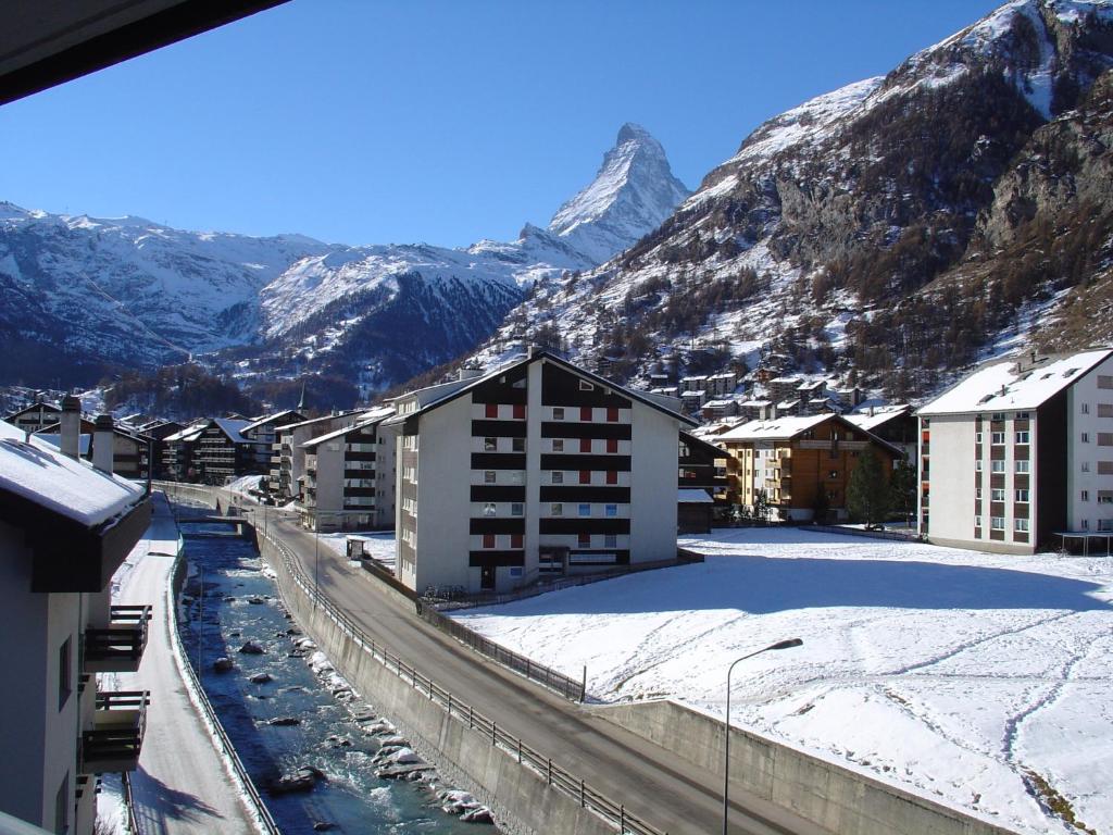 a city with snow covered buildings and a mountain at Haus Pirata in Zermatt