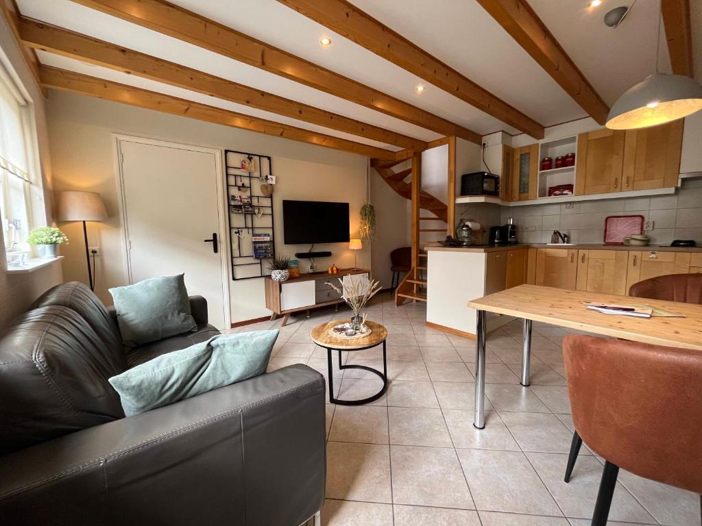 ein Wohnzimmer mit einem Sofa und einem Tisch in der Unterkunft De Bakkerij in Baaiduinen
