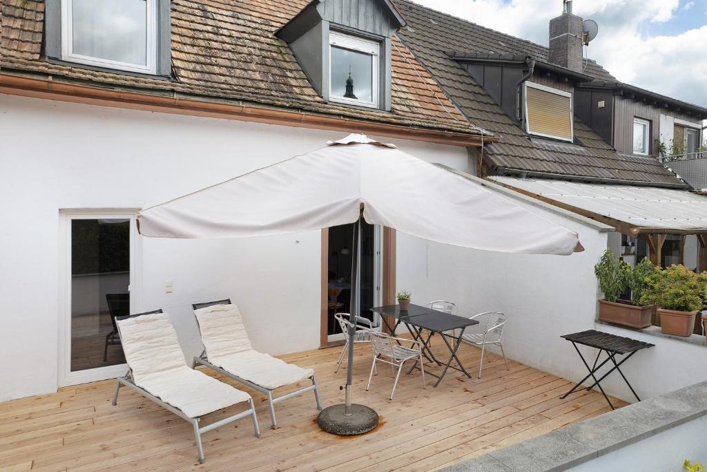 里格爾的住宿－Ferienhaus am Künstleratelier，一个带桌子和遮阳伞的庭院