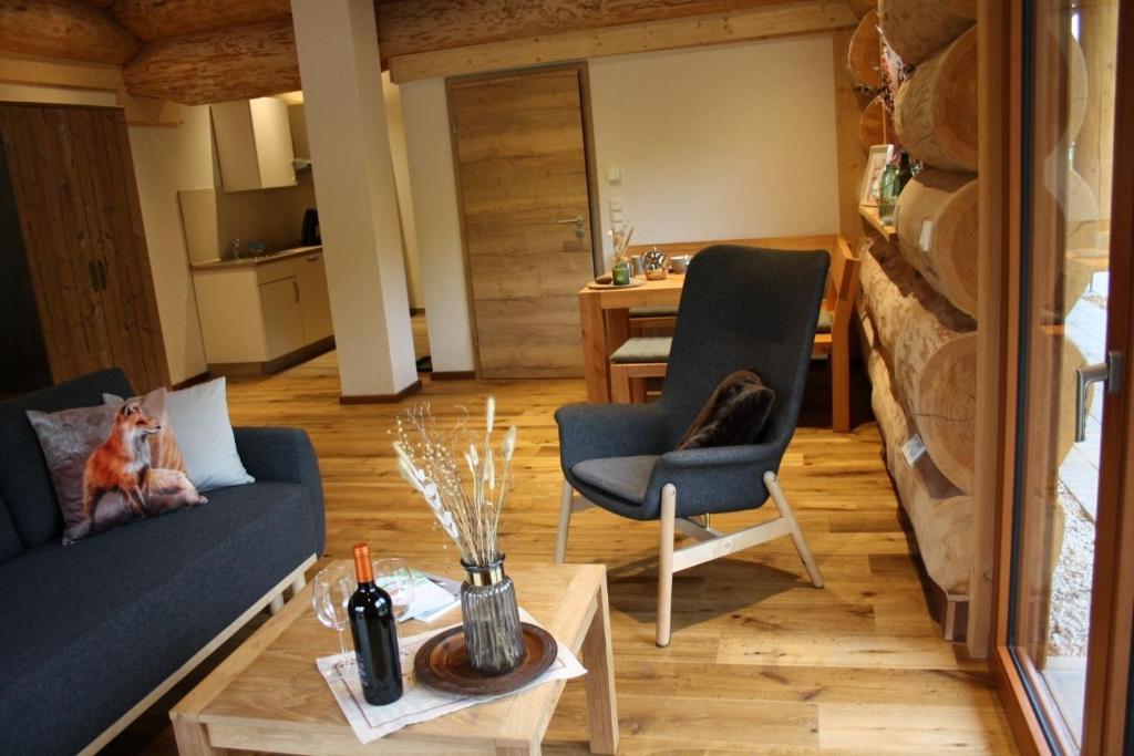 a living room with a couch and chairs and a table at Waldzeit Lodge - Ferienwohnung Fuchs in NeuhÃ¼tten