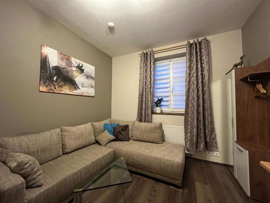 uma sala de estar com um sofá e uma janela em 3144 Ferien am SCHLOSS WALD Ap RAPHAEL em Wald