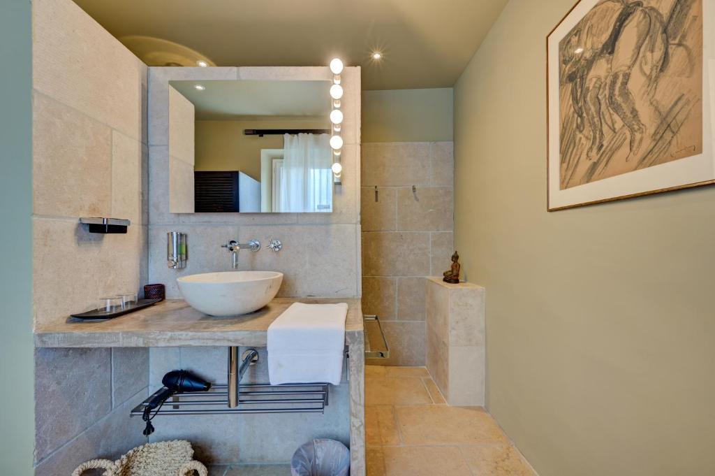 a bathroom with a sink and a mirror at Hostellerie Le Paradou in Lourmarin