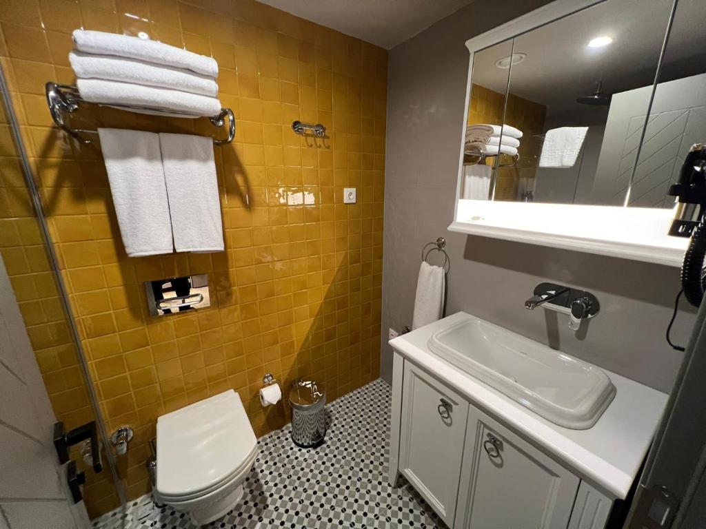 a bathroom with a sink and a toilet and a mirror at Weingart Suites Hotel in Istanbul
