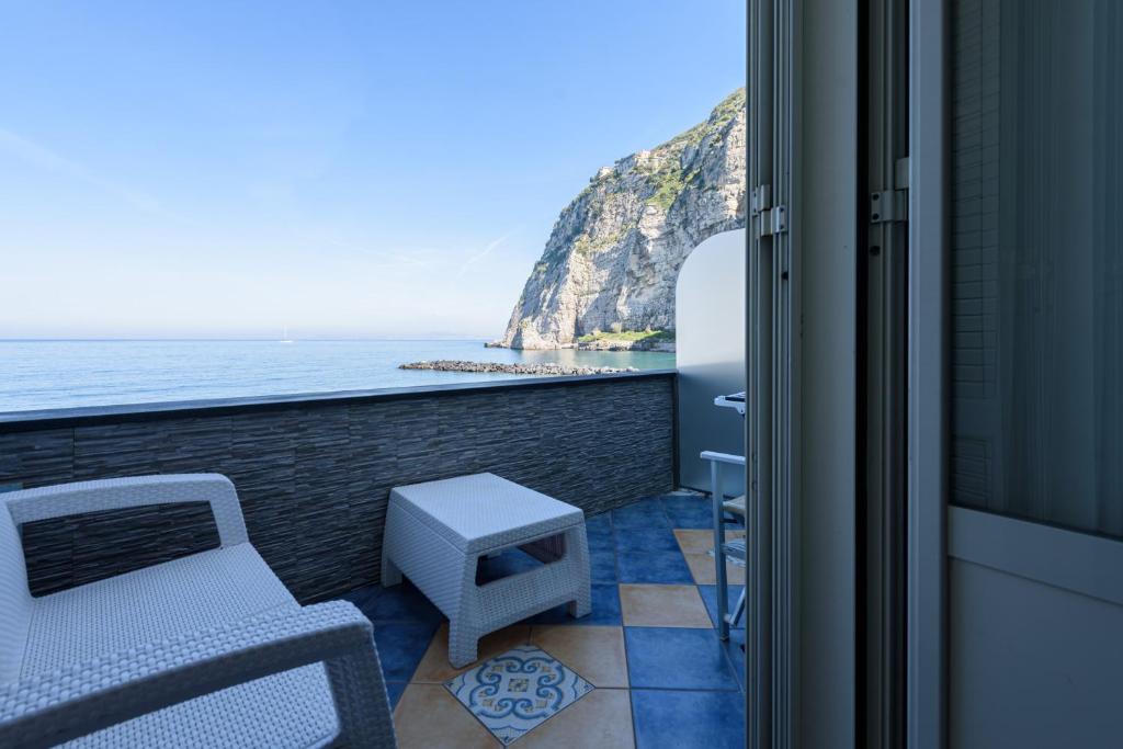 einen Balkon mit einem Stuhl und Meerblick in der Unterkunft [Sorrento Coast] - Suite 10 Meters From The Sea in Meta