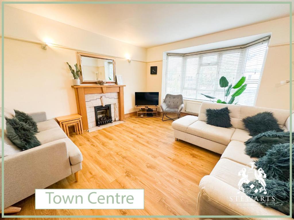 a living room with two couches and a fireplace at Town Centre Apartment Sleeps 9 in Bournemouth