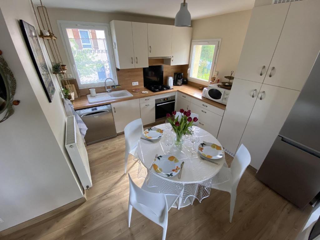 - une cuisine avec une table blanche et des chaises blanches dans l'établissement Le Semnoz, à Saint-Jorioz