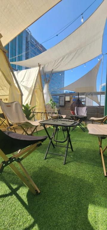 um grupo de cadeiras de jardim e tendas num telhado em Mizo Hotel em Seul