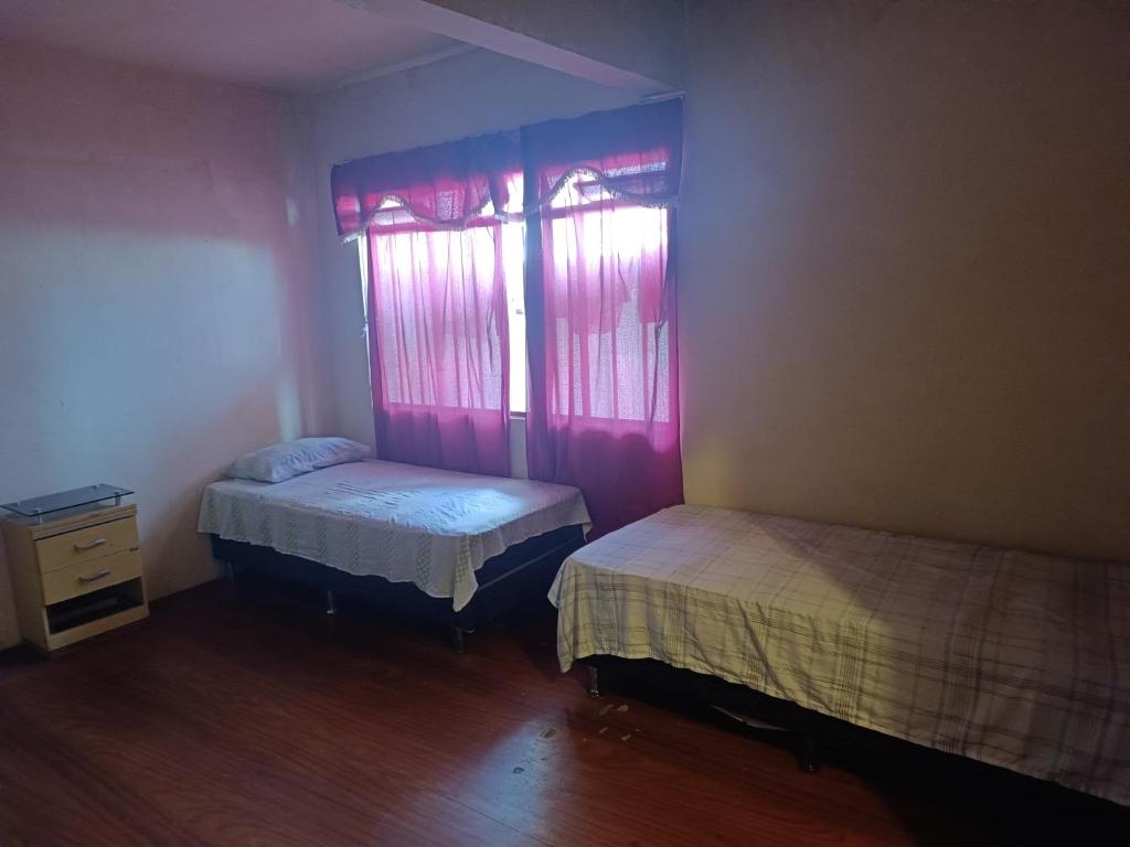 Zimmer mit 2 Betten und 2 Fenstern in der Unterkunft Assel Xaxim AP2 Curitiba in Curitiba