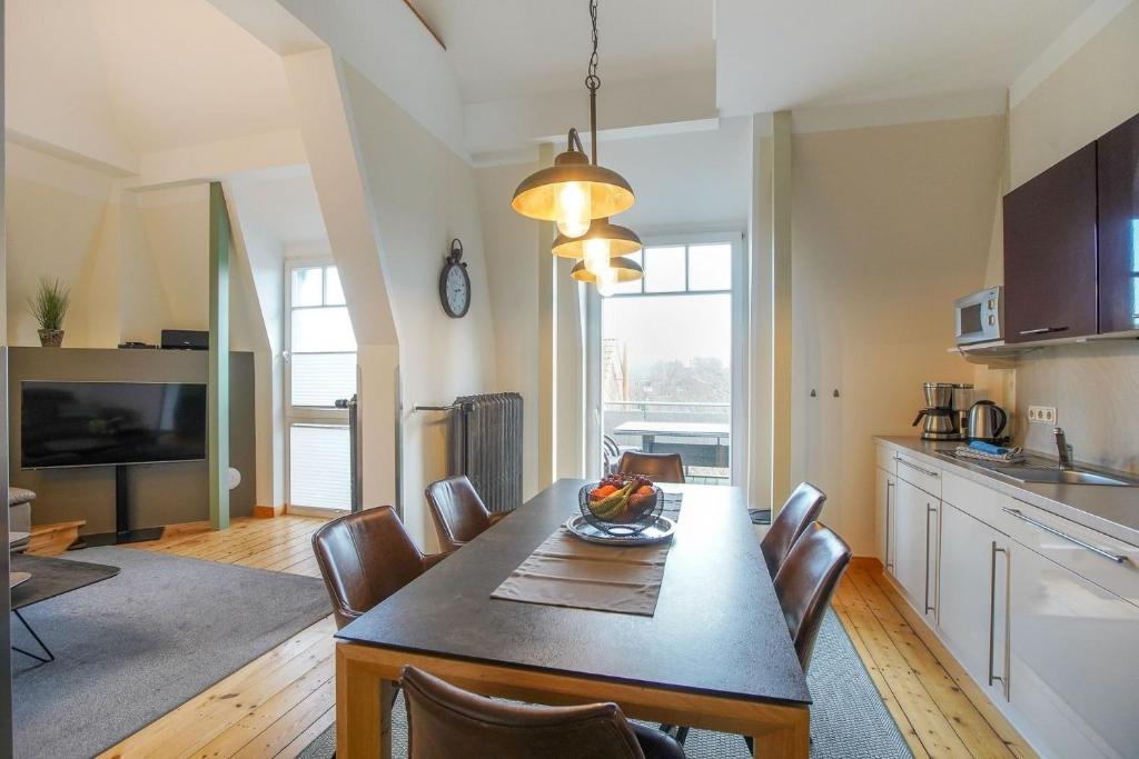Una cocina y un comedor con mesa y sillas. en FeWo Lieselotte, en Borkum