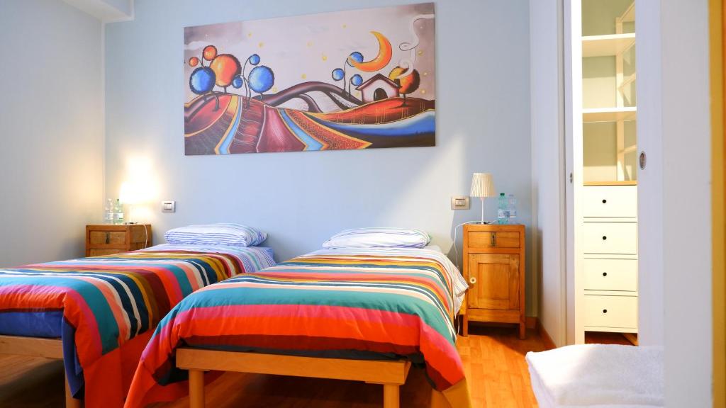 2 Betten in einem Zimmer mit Wandgemälde in der Unterkunft B&B del Cactus in Corridonia