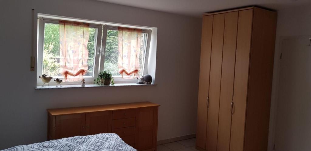 a bedroom with a bed and a window with pink curtains at Souterrain - a72405 in Rheinbach