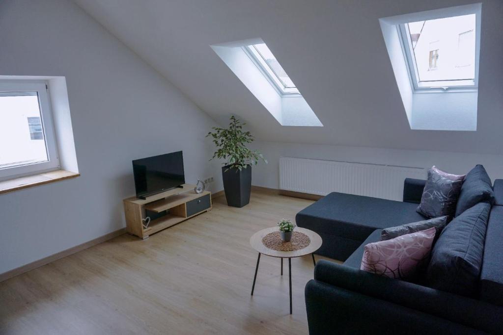 een woonkamer met een bank en een tv bij Ferienwohnung Ottobeuren in Ottobeuren