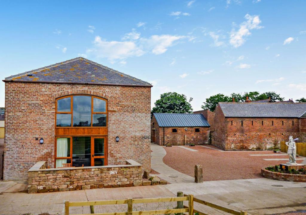 een bakstenen gebouw met een groot raam bij Fortress at Hadrians Wall in Irthington