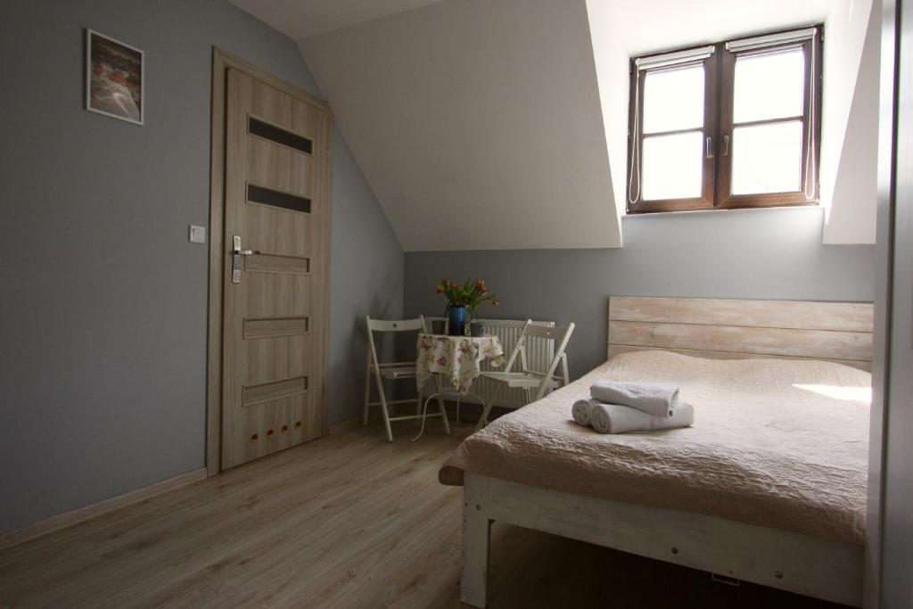 a bedroom with a bed and a window and a table at Pokoje Nadrzeczna 45 in Kazimierz Dolny