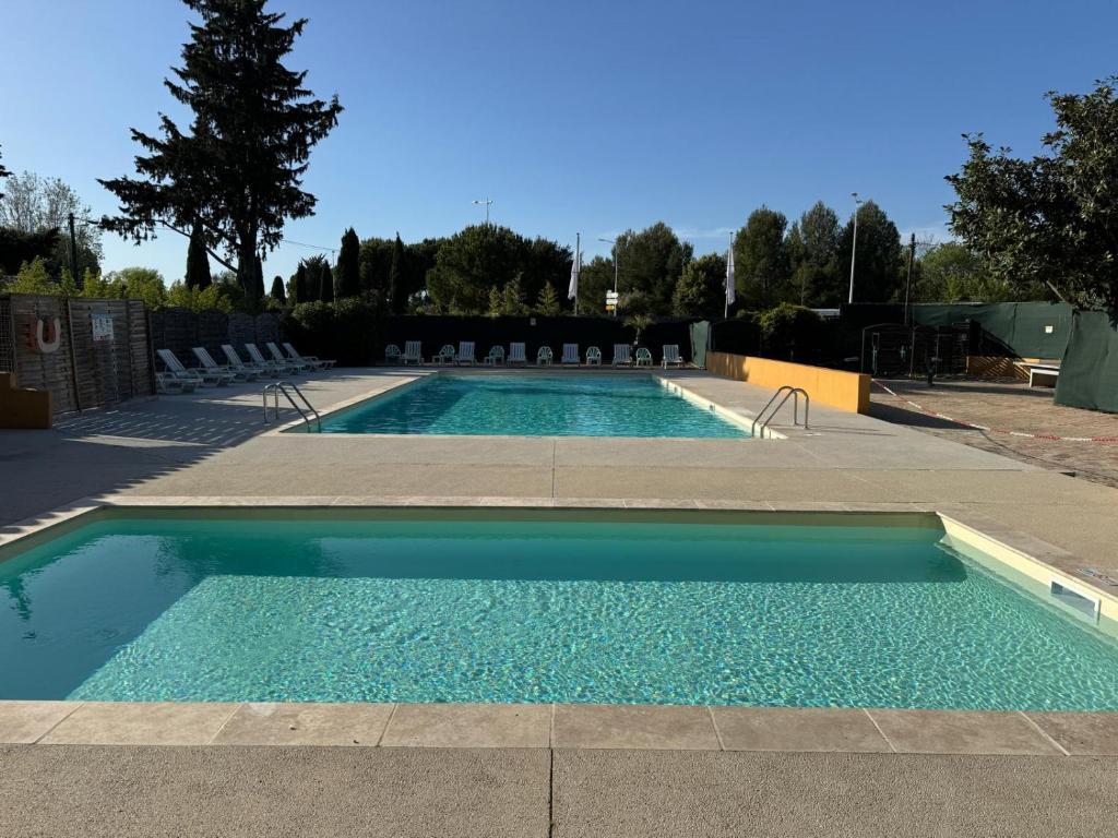 duży basen z krzesłami w obiekcie Camping de l'Arnel w mieście Villeneuve-lès-Maguelone