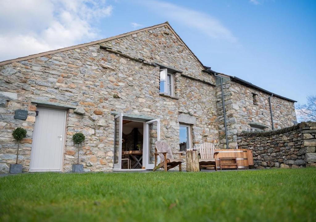 a stone house with two chairs and a table at Beltie in the Vale in Threlkeld