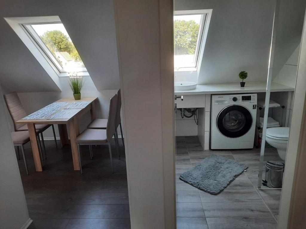 a small kitchen with a table and a washing machine at Villa Mariensiel 2OG li in Sande